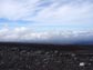 Photo of the twisting road, Mauna Loa's lava fields and clouds.