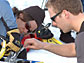 Photo shows Gretchen Hofmann and Tom Crombia carrying out a "field repair" on the rover.