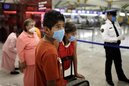 Passengers, wearing masks as a precaution against swine flu, prepare to depart from the Mexico City's International Airport in Mexico City, Tuesday, May 5, 2009.  Mexican officials lowered their flu alert level in the capital on Monday, and plan to allow cafes, museums and libraries to reopen this week, while world health officials weighed raising their pandemic alert to the highest level. (AP Photo/Alexandre Meneghini)