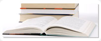 Resources image which includes a stack of books with one book lying open.