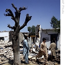 Local people are seen at the rubble of a police station allegedly destroyed by Taliban in Kadokhel in Buner district of Pakistan, 30 Apr 2009