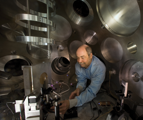 Tom Hurry of Plasma Physics leans into the TA-North experimental chamber to adjust the target positioner and particle beam diagnostics before an experiment at the Trident Laser Facility. Laboratory scientists use Trident, which is located at Technical Area 35, to create and study extreme states of matter, such as plasma, by shining a brief, intense pulse of light onto a solid target, which heats a small volume of material into a million-degree microplasma. The round cylindrical objects behind Hurry are porthole covers of the chamber.