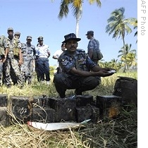 Sri Lankan Air Force officer examines explosives recovered from site of downed Tamil Tiger light aircraft in Katunayaka, near Colombo, 21 Feb 2009<br />
