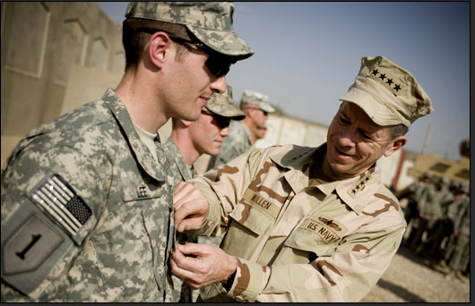 U.S. Navy Adm. Mike Mullen, chairman of the Joint Chiefs of Staff, promotes U.S. Army 1st Lt. Travis Lee to captain during a ceremony at Combat Outpost Banchee, Iraq, March 1, 2008.