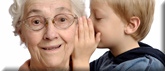Grandma listening as boy whispers in her ear