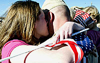 Bethany King kisses her husband, Spc. Daniel King, after the conclusion of the 39th Brigade Combat Team's welcome home Ceremony Nov. 6. Bethany's husband and father, Sgt. David King, were deployed to Iraq with the 39th BCT. Sgt Brandon Krahmer, 4th Public Affairs Detachment