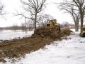 A worker increases the height of a dike with construction equipment in Fargo