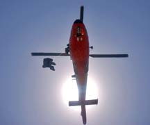 Coast Guard helicopter lowering rescue swimmer