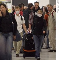 Some travelers coming from Cancun, Mexico, wear protective masks, as they arrive at the airport in Duesseldorf, Germany, 30 Apr 2009