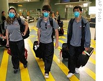 Students wear masks after showing flu like symptoms on their arrival from the United States at Auckland International Airport, Auckland, New Zealand, Tuesday, 28 April 2009