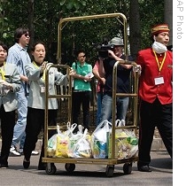 Hotel workers push cart loaded with food to sealed-off hotel where Mexican travelers are being held under quarantine in Beijing, 04 May 2009