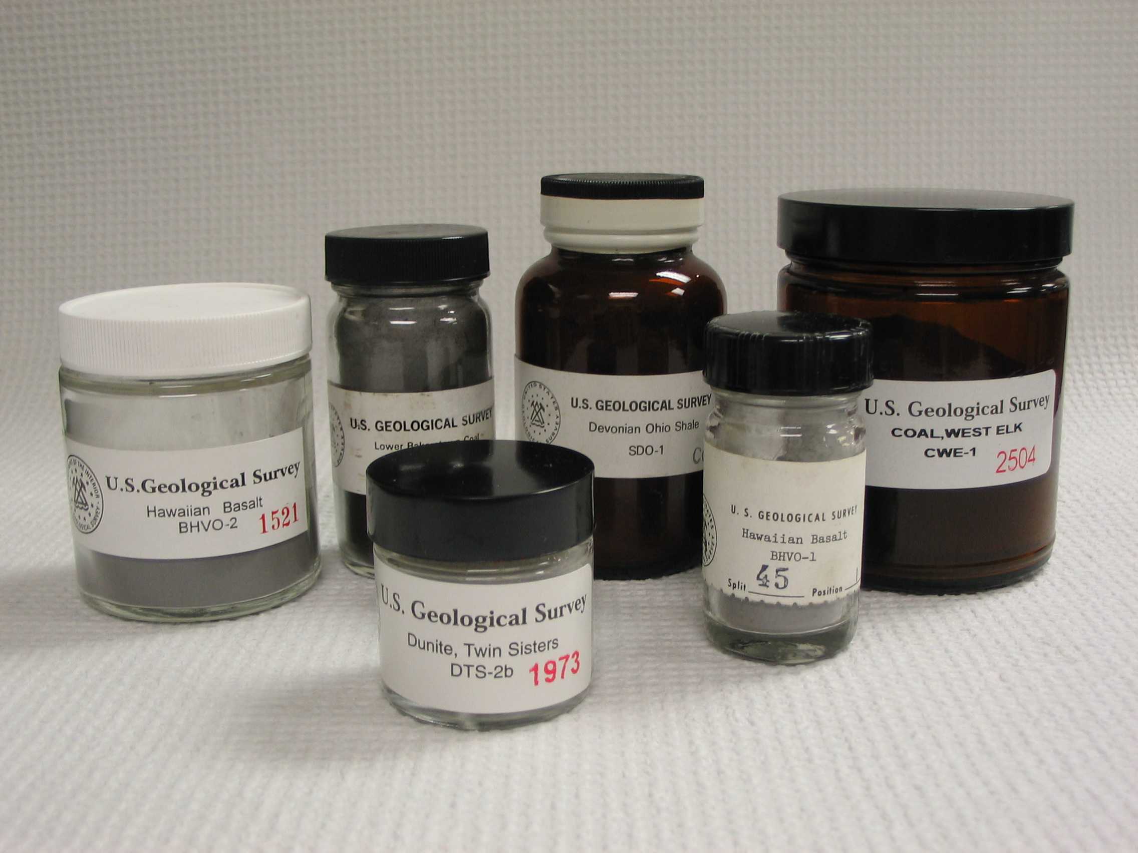 Photo of geochemical reference materials in bottles and jars.
