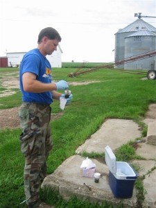 USGS scientist sampling manure on farm.