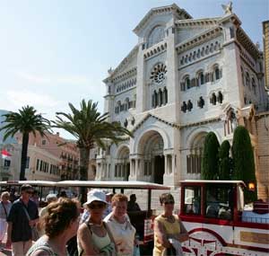 Tourists walk past the Cathedral of Monaco, June 3, 2004. [© AP Images]