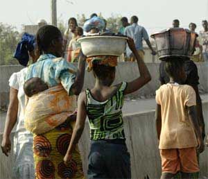 Women and children walk across highway overpass in Conakry, Guinea, February 15, 2007. [© AP Images]