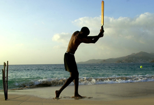 A man plays a pick-up game of cricket on Grand Anse Beach, Grenada, May 27, 2003. [© AP Images]