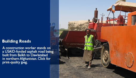 Building Roads: A construction worker stands on a USAID-funded asphalt road being built from Balkh to Dawlatabad in northern Afghanistan.  Click for print-quality jpeg - link will open in a new window.