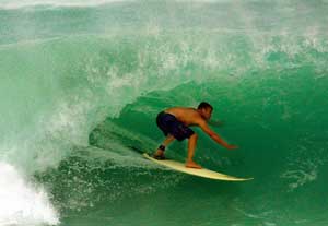 Surfer rides a wave at Windsor Beach in Tuckers Town, Bermuda. September 9, 2001. [© AP Images]