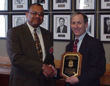 Assistant U.S. Attorney Thomas Karol receives commendation from Samuel Holland.