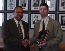 IRS-CI Special Agent Jeffrey Paul recieves commendation from Samuel Holland.