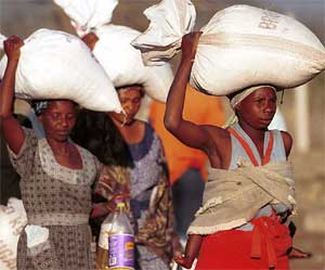 Women carry bags of food home near Magomba, Swaziland, August 10, 2002. [© AP Images]