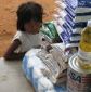 Date: 04/07/2009 Location: Rome, Italy Description: Little girl standing next to food supplies © UN Rome Photo