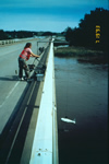USGS scientist lowering a water-quality sampler into the Iowa River near Marengo, IA, (site ID 05453100). during the 1993 flood of the upper Mississippi River Watershed. The samples were analyzed for nutrients and pesticides