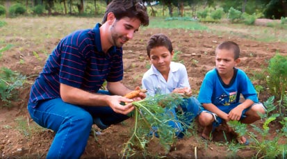 Volunteer educating children about planting