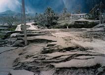 Volcanic ash and lahar deposits cover roads and clog drainages