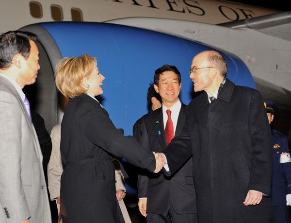 Secretary of State Clinton shakes hands with Embassy Charge d'Affairs James P. Zumwalt on the tarmac at Tokyo's Haneda Airport.