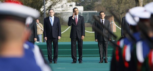 U.S. President Barack Obama, center, stands with French President Nicolas Sarkozy, right, and British Prime Minister Gordon Brown during a military ceremony after they crossed the Passerelle bridge in Strasbourg, France, during the NATO summit, Saturday, April 4, 2009.