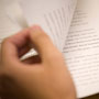 Image of a hand turning a page of text