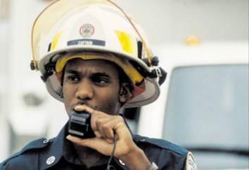 Firefighter speaking into walkie-talkie.