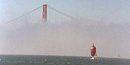 Fog envelopes San Francisco Bay, leaving only the top of the Golden Gate Bridge visible.
