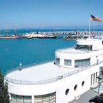 The Aquatic Park Bathhouse building with Hyde Street Pier and the historic ships in the background.