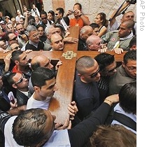 Christian worshippers carry cross on the Via Dolorosa towards the Church of Holy Sepulcher in Jerusalem's Old City, 10 Apr 2009