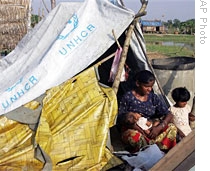 A woman feeds her baby in a makeshift tent in Twantay, south of Yangon, 30 Ap 30 2009