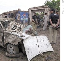 Pakistani police officers examine site of suicide bombing near Peshawar, 05 May 2009
