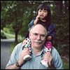 Photo of Older Man Carrying Young Girl on Shoulders