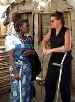 Enter the International Development and Disability pages here, Photo: An American and an African woman, both who uses arm crutches, talk outside a traditional African home