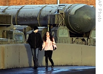A couple passes by Russian ICBM Topol, reported by NATO as SS-25 Sickle, in St. Petersburg, Russia