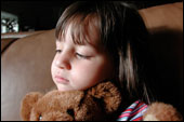 sad looking girl holding teddy bear