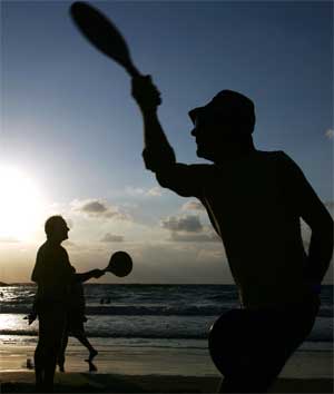 Beachgoers play paddleball on the beach in Tel Aviv, Israel, July 5, 2005. [© AP Images]