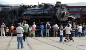 Visitors watch as a steam locomotive turns on the turntable, a rotating bridge