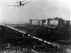 A C-54 flies over a graveyard, and close to some apartments buildings, while making its landing approach at Tempelhof Airport. 