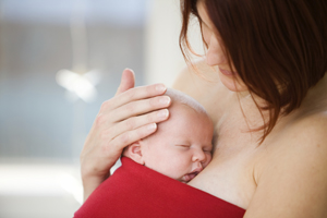 a woman holding an infant skin to skin
