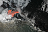 Lava plunges into a submarine tube at the middle entry on the Waikupanaha delta. At the right edge of the photo are steaming cracks, clear evidence that the new delta is inherently unstable.