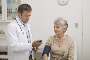Physician taking an woman's blood pressure.