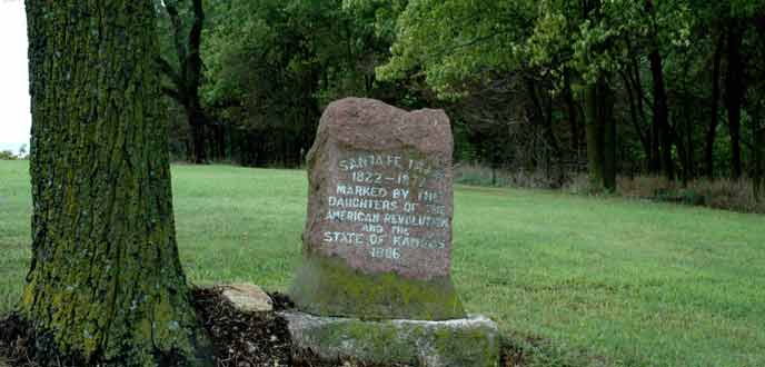 A solitary granite marker stands next to a tree on the Santa Fe Trail near Council Grove, Kansas