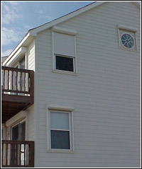 Howarth's hurricane shutters installed at each window with one partially closed at second floor. FEMA Photo
